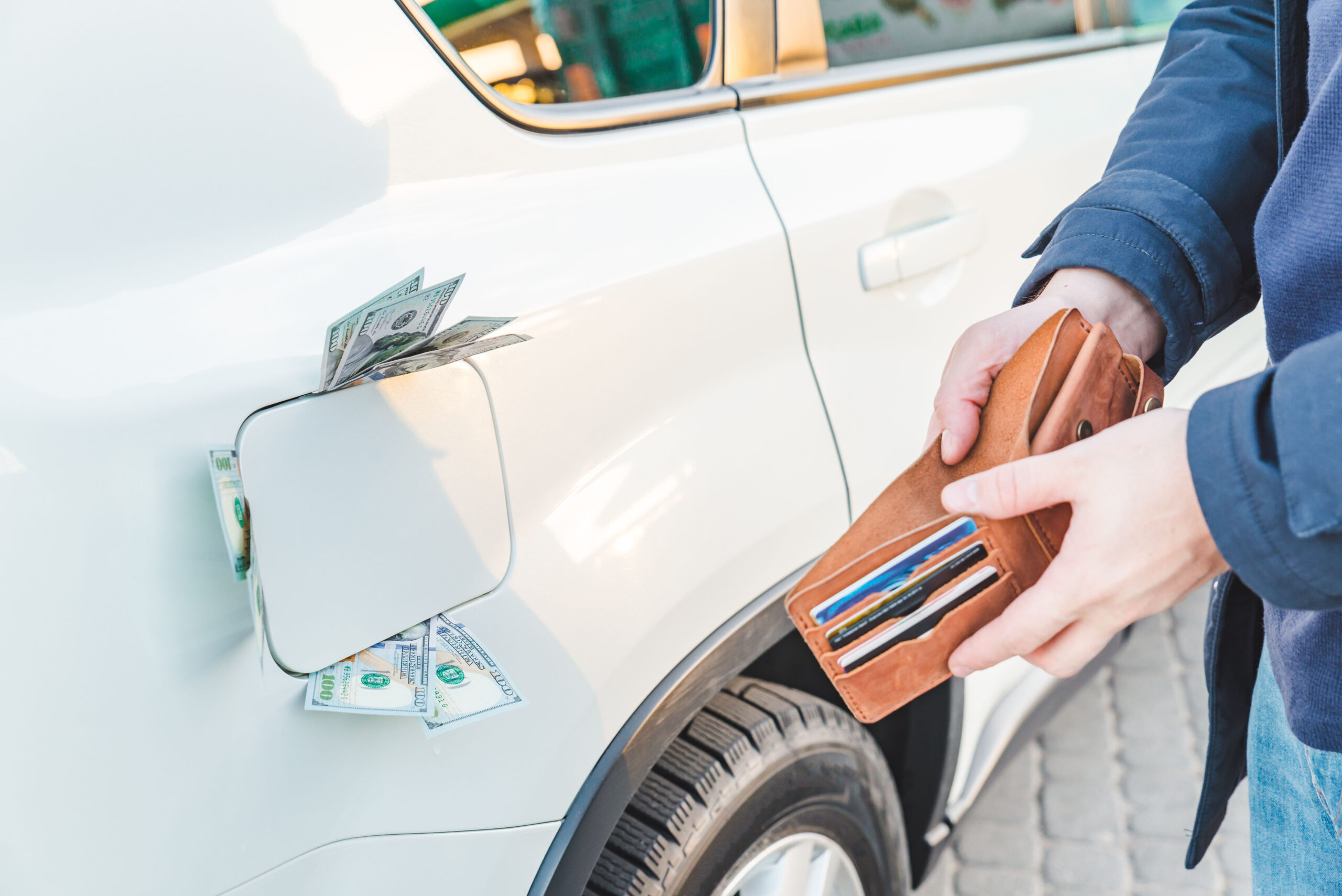 man standing with empty wallet. dollars money in car tank. gas s